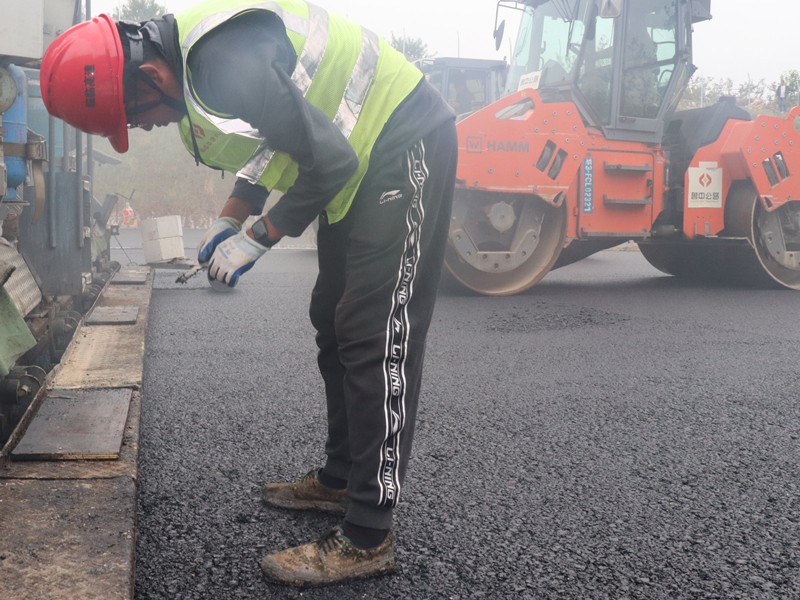 5、油層施工員任慶波隨時測量瀝青層松鋪厚度_副本